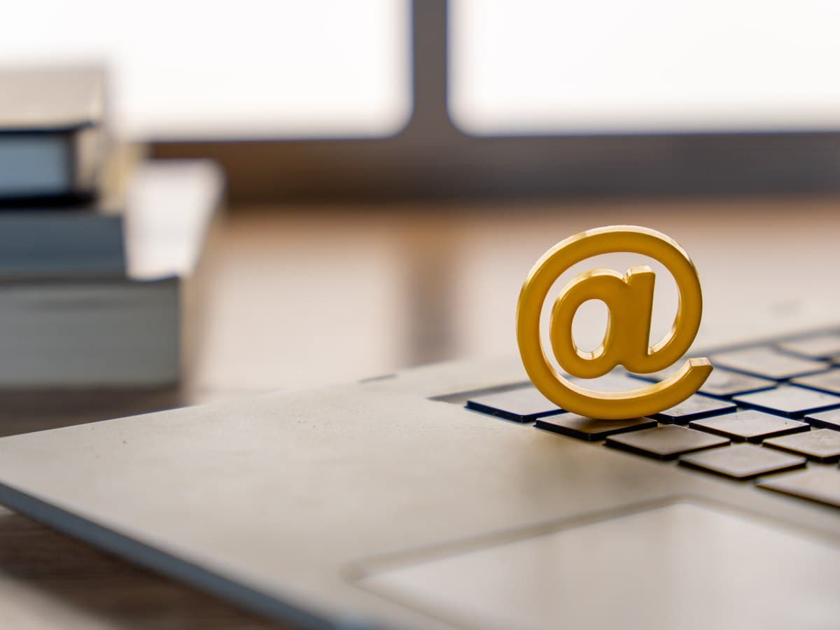 Gold @ symbol resting on a laptop keyboard
